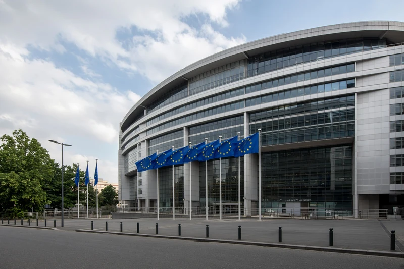 Sede Commissione europea a Bruxelles con bandiere UE; illustrazione editoriale IA.